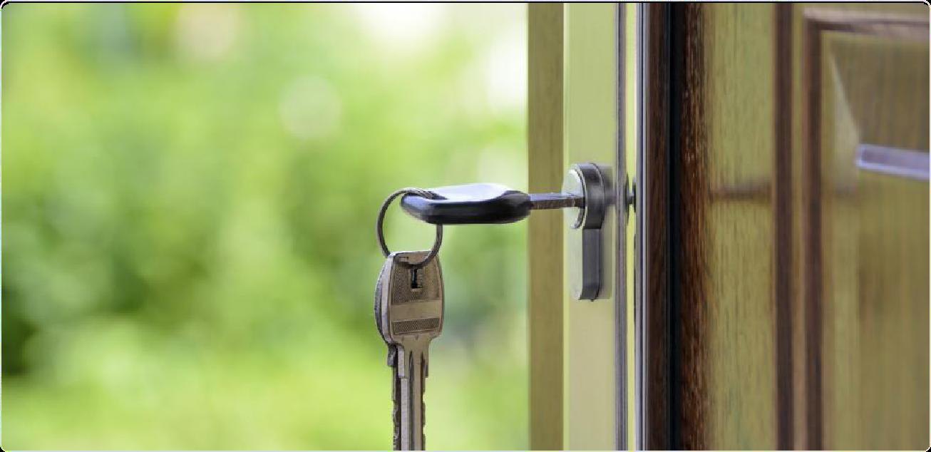 A house key in an unlocked front door, keys handed over at move-in for an off-campus rental near UNC Charlotte
