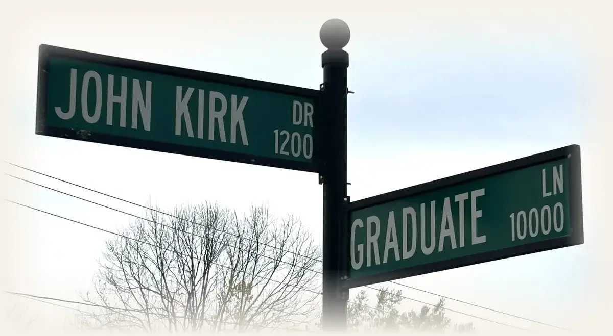 John Kirk Drive and Graduate Lane street signs at the edge of the UNC Charlotte campus